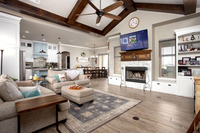 9191 E Strawberry Fields Dr, Canyon, TX 79119 - living room featuring ceiling fan, arched walkways, a large fireplace, wood finished floors, and healthy amount of natural light