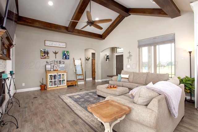 9191 E Strawberry Fields Dr, Canyon, TX 79119 - living room featuring ceiling fan, arched walkways, beam ceiling, wood finished floors, and baseboards