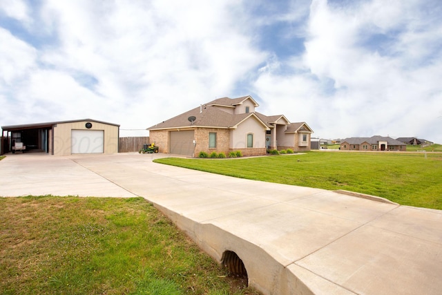 9191 E Strawberry Fields Dr, Canyon, TX 79119 - view of front facade featuring a front lawn, a garage, driveway, roof with shingles, and an outdoor structure