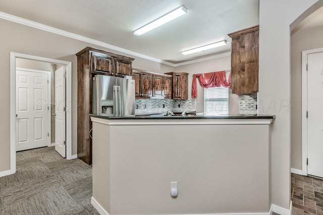 7110 Bennett St, Amarillo, TX 79119 - kitchen with stainless steel fridge with ice dispenser, dark countertops, arched walkways, crown molding, and tasteful backsplash