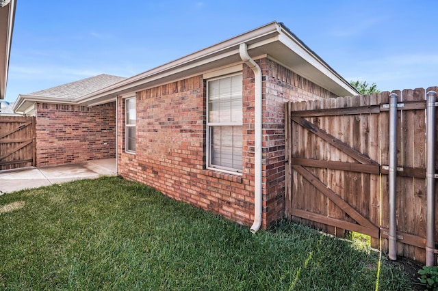 7110 Bennett St, Amarillo, TX 79119 - view of home's exterior with a gate, brick siding, and a shingled roof
