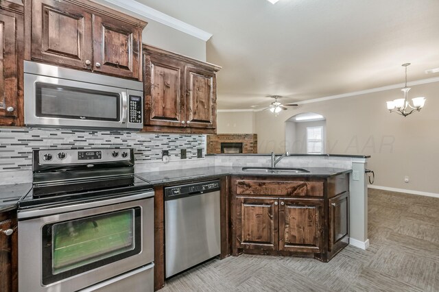 7110 Bennett St, Amarillo, TX 79119 - kitchen featuring appliances with stainless steel finishes, a peninsula, crown molding, decorative backsplash, and a ceiling fan