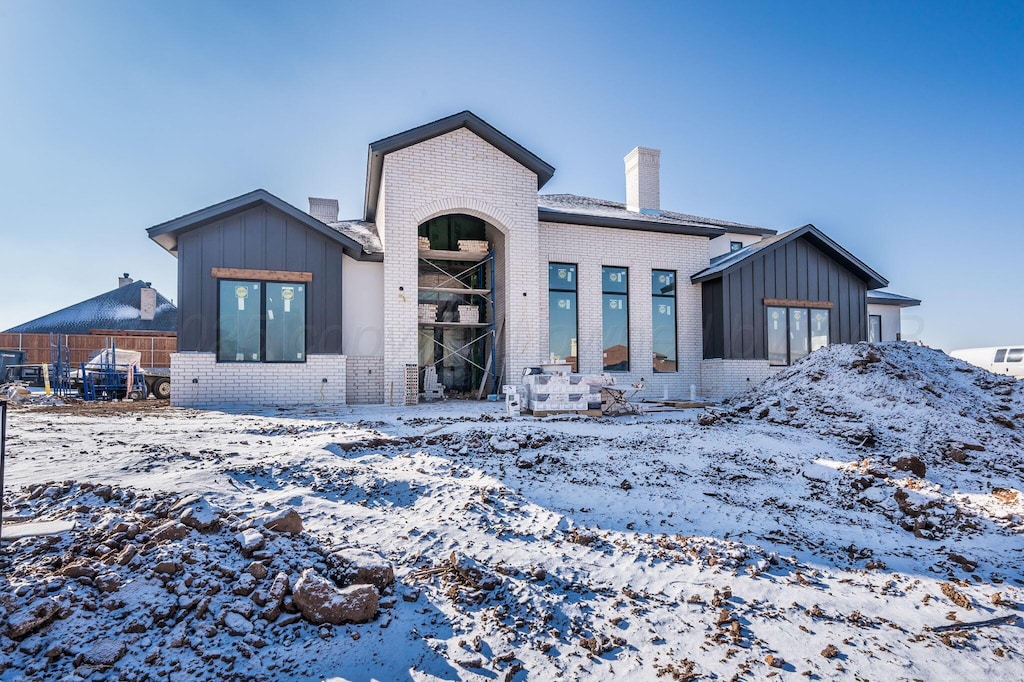 view of snow covered back of property