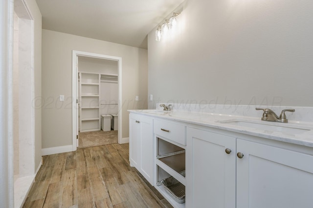 505 Pratt St, Claude, TX 79019 - full bathroom with a sink, wood finished floors, baseboards, and a walk in closet