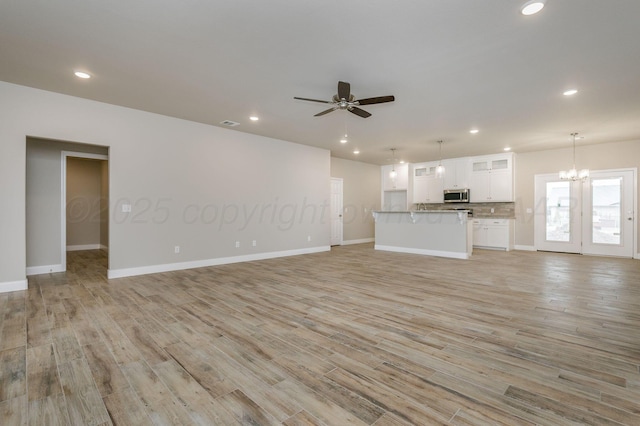 505 Pratt St, Claude, TX 79019 - unfurnished living room with ceiling fan with notable chandelier, baseboards, light wood finished floors, and recessed lighting