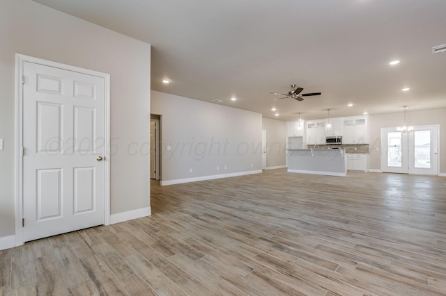 505 Pratt St, Claude, TX 79019 - unfurnished living room featuring light wood finished floors, ceiling fan with notable chandelier, baseboards, and recessed lighting
