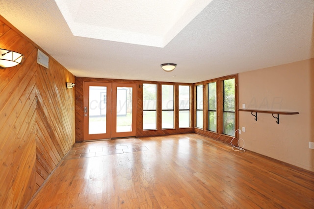 5507 Harvard St, Amarillo, TX 79109 - unfurnished living room featuring a textured ceiling, light wood-style flooring, and wooden walls