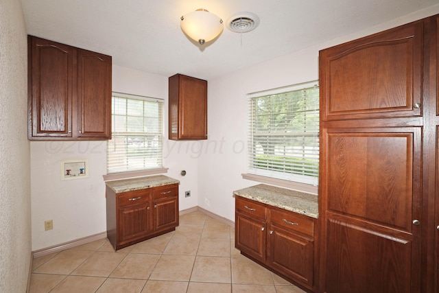 5507 Harvard St, Amarillo, TX 79109 - laundry room with hookup for a washing machine, cabinet space, hookup for an electric dryer, light tile patterned floors, and baseboards