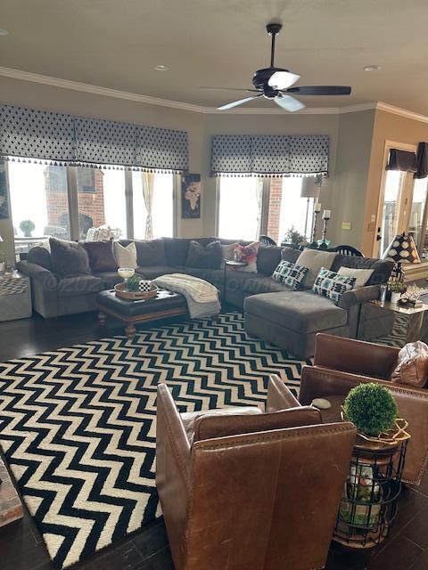 living area featuring ceiling fan, plenty of natural light, and ornamental molding