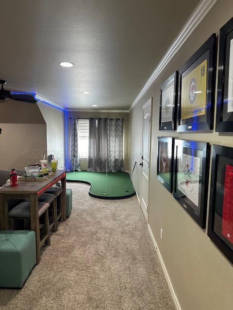 rec room featuring carpet floors, crown molding, and baseboards
