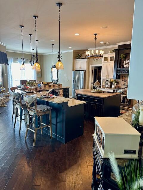 4301 Fairway Dr, Amarillo, TX 79124 - kitchen with a large island, stainless steel fridge with ice dispenser, ornamental molding, dark wood-type flooring, and a chandelier