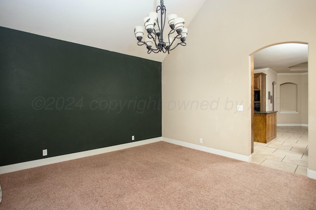 carpeted empty room with lofted ceiling and an inviting chandelier