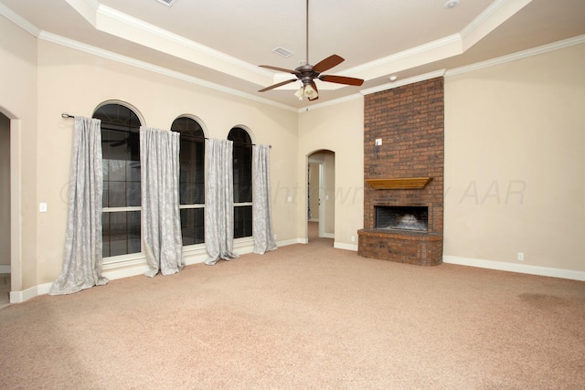 unfurnished living room featuring a tray ceiling, crown molding, ceiling fan, and carpet