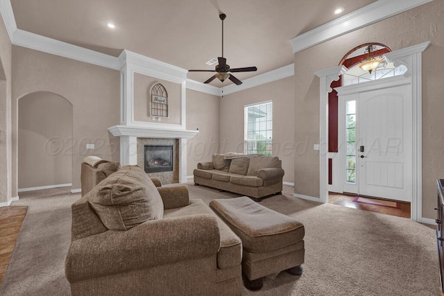 8313 Irvington Ct, Amarillo, TX 79119 - carpeted living area with crown molding, arched walkways, ceiling fan, a tiled fireplace, and baseboards