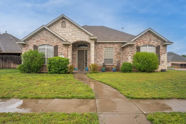 8313 Irvington Ct, Amarillo, TX 79119 - french provincial home featuring brick siding, a front yard, and a shingled roof