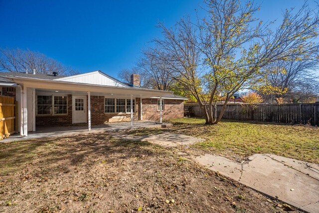 4204 Roxton Dr, Amarillo, TX 79109 - rear view of house featuring a fenced backyard, a chimney, brick siding, and a patio area