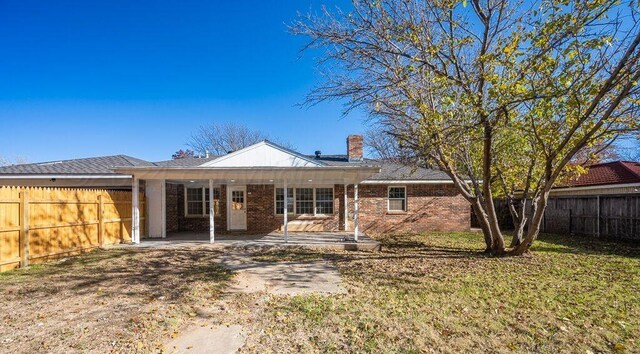 4204 Roxton Dr, Amarillo, TX 79109 - back of property featuring a fenced backyard, a chimney, and brick siding