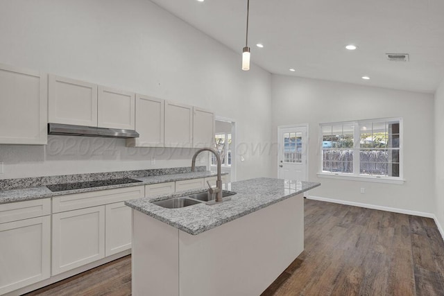 4204 Roxton Dr, Amarillo, TX 79109 - kitchen with black electric cooktop, dark wood-style floors, recessed lighting, high vaulted ceiling, and a center island with sink