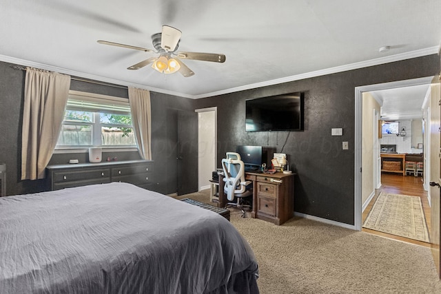 carpeted bedroom featuring ceiling fan and crown molding