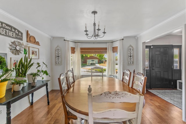 dining room featuring ornamental molding, hardwood / wood-style flooring, and a chandelier