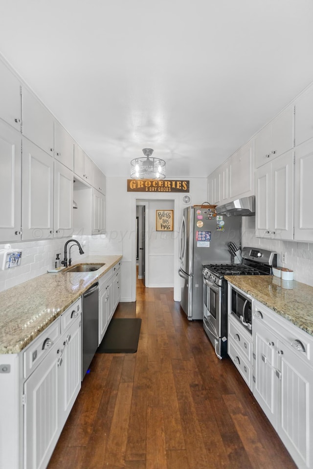 kitchen with dark hardwood / wood-style flooring, decorative backsplash, sink, white cabinetry, and appliances with stainless steel finishes