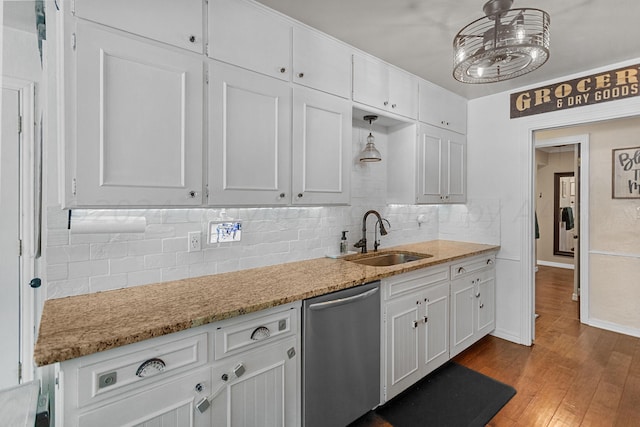 kitchen featuring white cabinets, hardwood / wood-style flooring, sink, stainless steel dishwasher, and decorative light fixtures