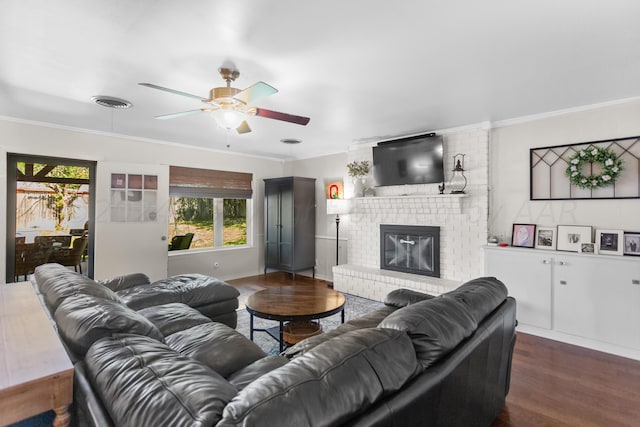 living room featuring a fireplace, ceiling fan, dark hardwood / wood-style floors, and crown molding