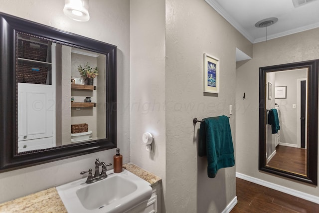 bathroom featuring wood-type flooring, sink, and crown molding