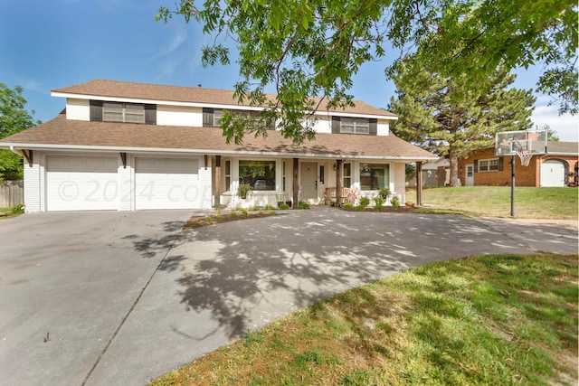 view of front facade with a garage, a porch, and a front lawn