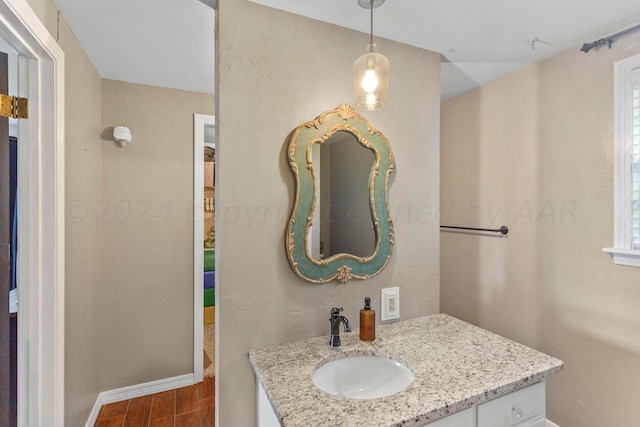 bathroom with a wealth of natural light, wood-type flooring, and vanity