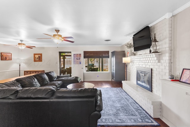 living room featuring a fireplace, dark hardwood / wood-style floors, ceiling fan, and ornamental molding