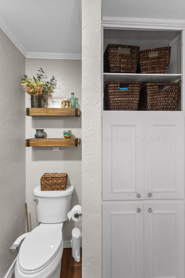 bathroom featuring toilet, hardwood / wood-style floors, and crown molding