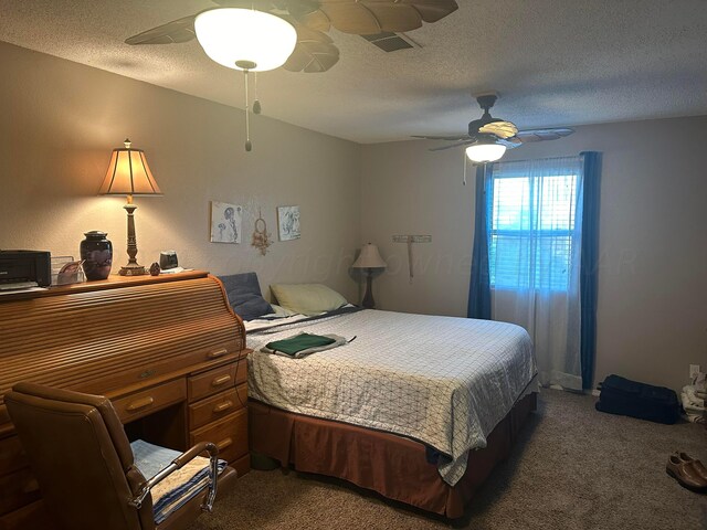 bedroom with a textured ceiling, dark colored carpet, and ceiling fan