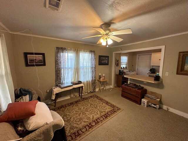 living area featuring ornamental molding, carpet, a textured ceiling, and ceiling fan