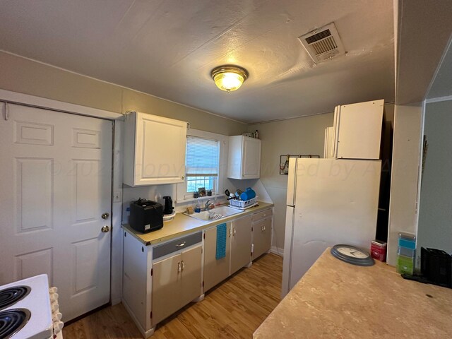 kitchen featuring white cabinetry, light hardwood / wood-style flooring, sink, and white appliances