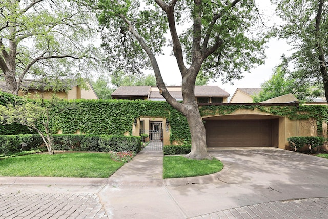 6 Woodstone St, Amarillo, TX 79106 - view of property hidden behind natural elements featuring stucco siding, concrete driveway, a garage, and a front yard