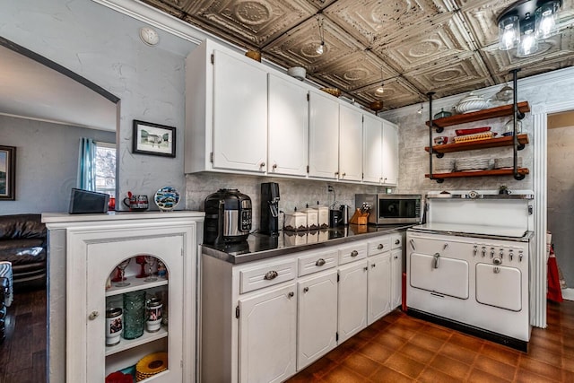 kitchen featuring an ornate ceiling, open shelves, stainless steel countertops, stainless steel microwave, and white cabinetry