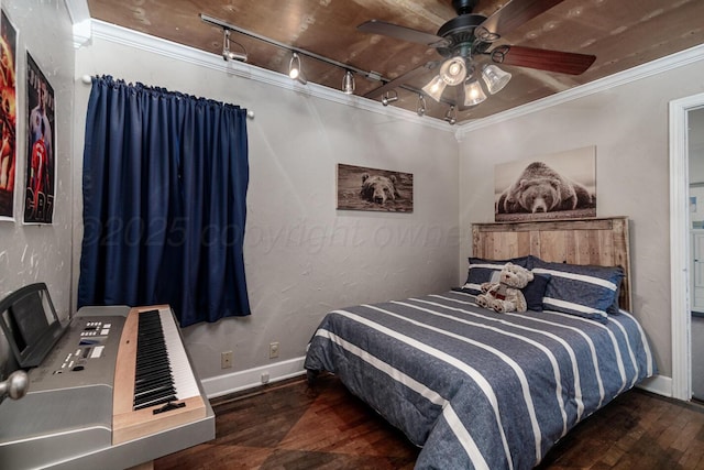 bedroom featuring crown molding, rail lighting, dark wood-type flooring, a ceiling fan, and baseboards