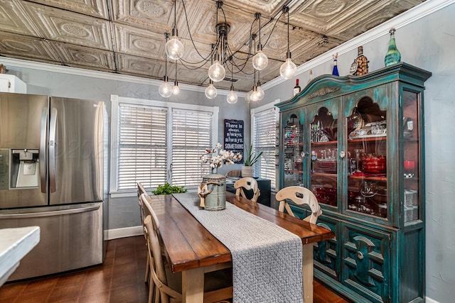 dining area with a notable chandelier, baseboards, an ornate ceiling, and crown molding