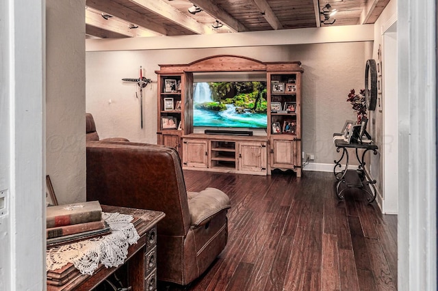 living area featuring a textured wall, wood finished floors, beam ceiling, and baseboards