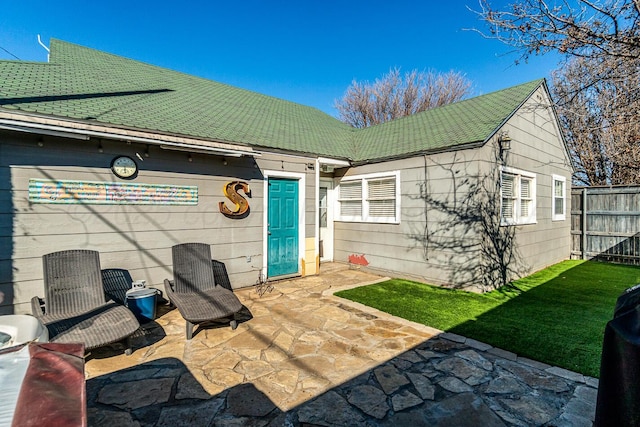 rear view of house with a patio and fence