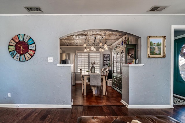 dining room featuring an inviting chandelier, baseboards, visible vents, and wood finished floors