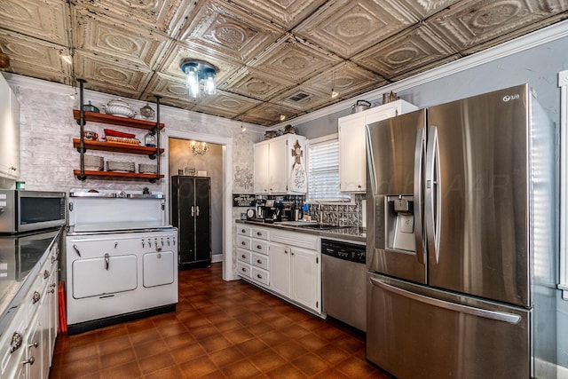 kitchen with an ornate ceiling, dark floors, appliances with stainless steel finishes, white cabinets, and a sink