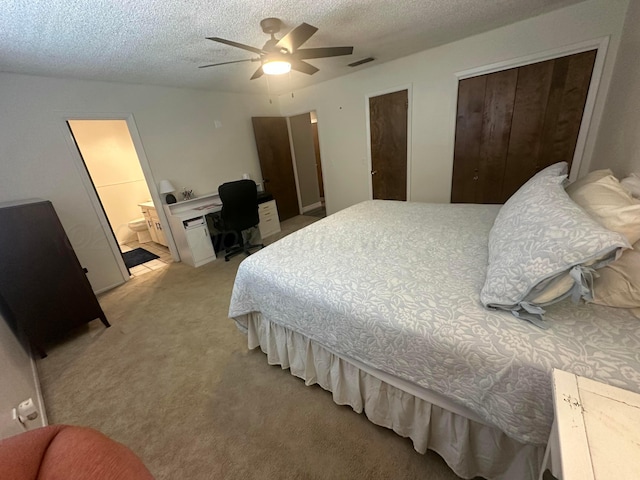 313 Mustang St, Fritch, TX 79036 - bedroom with an office area, light carpet, a textured ceiling, multiple closets, and connected bathroom