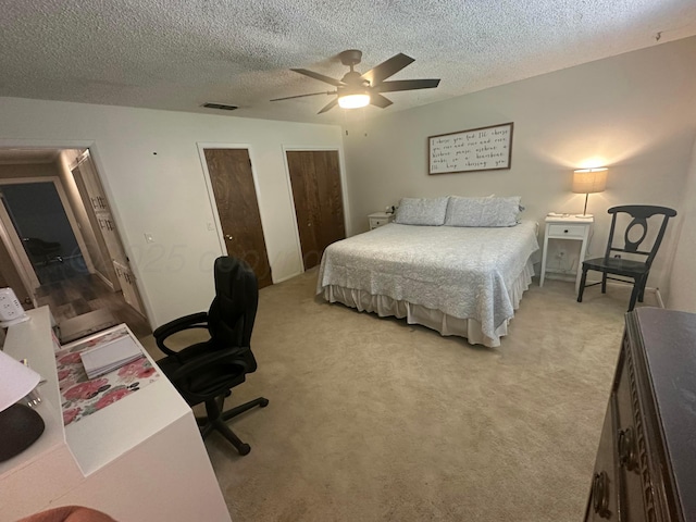 313 Mustang St, Fritch, TX 79036 - bedroom featuring two closets, a textured ceiling, light colored carpet, and a ceiling fan