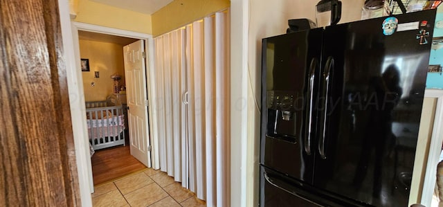 kitchen featuring black refrigerator with ice dispenser and light tile patterned floors