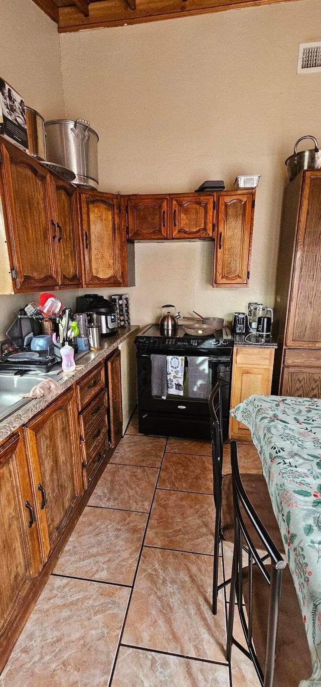 kitchen with light tile patterned floors and electric range