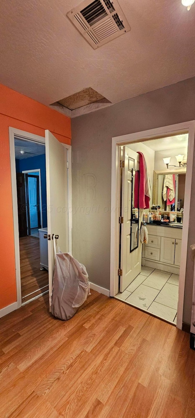 bedroom featuring light hardwood / wood-style flooring and ensuite bathroom