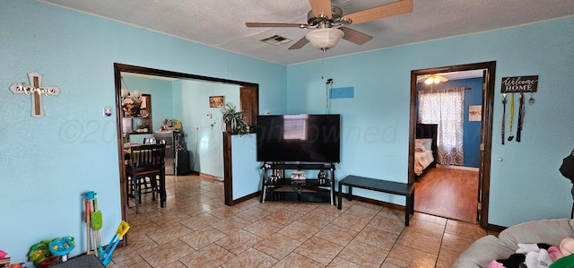 living room with ceiling fan and a textured ceiling