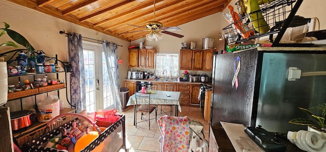 kitchen featuring vaulted ceiling, sink, dishwashing machine, light tile patterned floors, and wooden ceiling